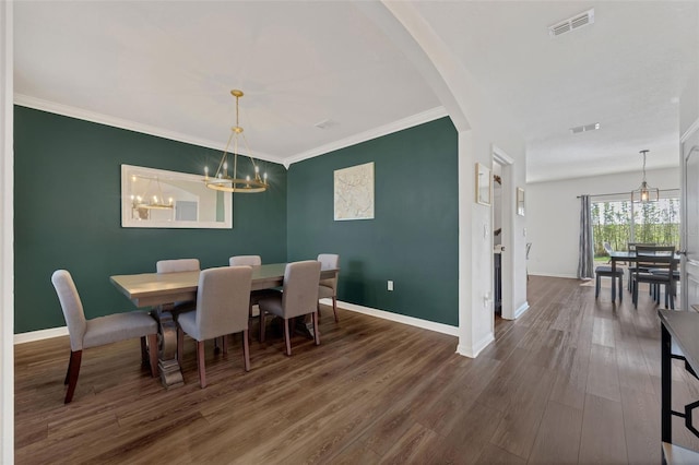 455 Lazio Cir, Debary, FL 32713 - dining space with baseboards, wood finished floors, arched walkways, a chandelier, and ornamental molding