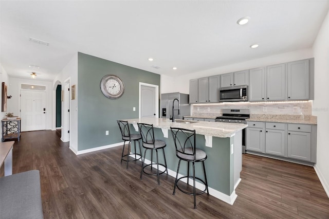455 Lazio Cir, Debary, FL 32713 - kitchen with stainless steel appliances, a sink, an island with sink, gray cabinets, and tasteful backsplash