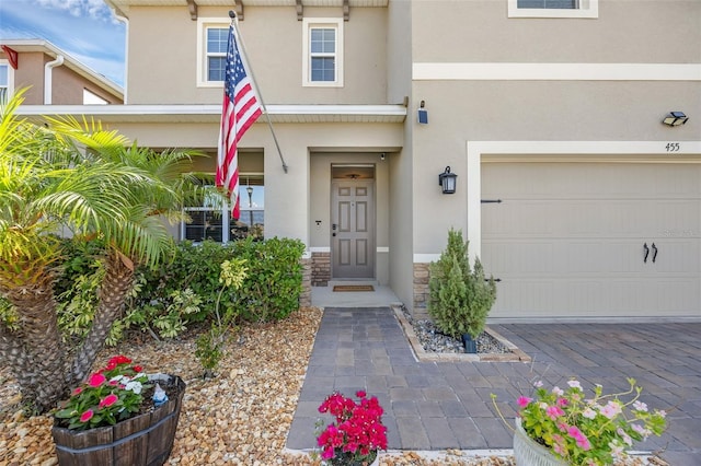 455 Lazio Cir, Debary, FL 32713 - property entrance featuring stucco siding, stone siding, and a garage