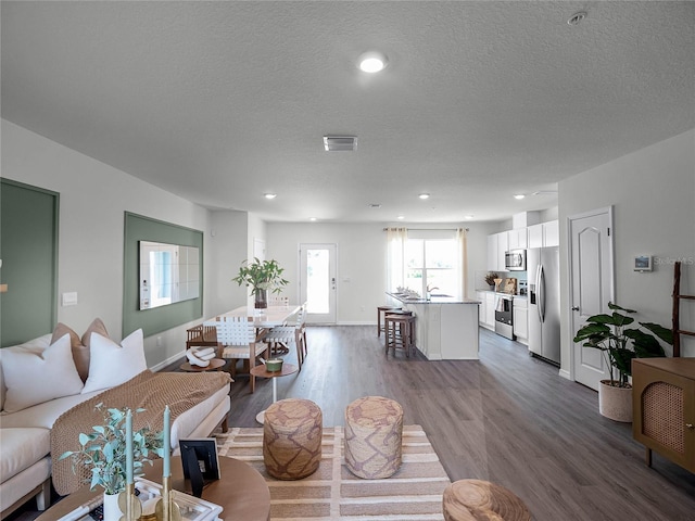 1562 Dalehurst Ln, Kissimmee, FL 34744 - living area with dark wood-style flooring, a textured ceiling, baseboards, and recessed lighting