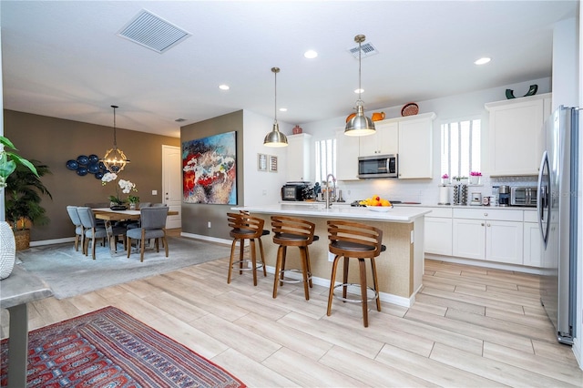 6543 Orange Cream Aly, Winter Garden, FL 34787 - kitchen with appliances with stainless steel finishes, wood tiled floors, light countertops, white cabinetry, and recessed lighting