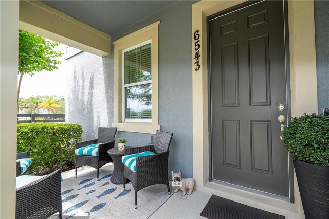 6543 Orange Cream Aly, Winter Garden, FL 34787 - view of exterior entry with stucco siding and a porch