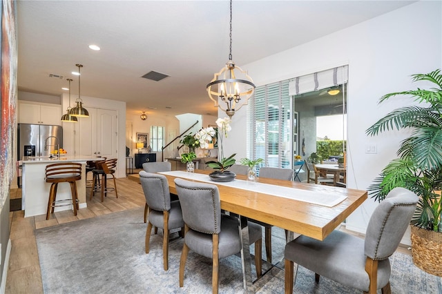 6543 Orange Cream Aly, Winter Garden, FL 34787 - dining room with a chandelier, healthy amount of natural light, recessed lighting, stairway, and light wood-style floors