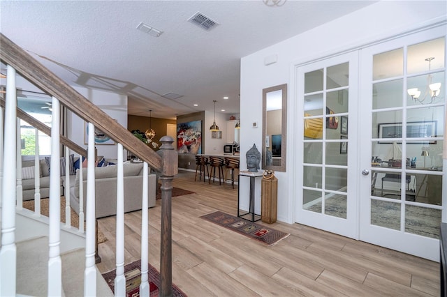6543 Orange Cream Aly, Winter Garden, FL 34787 - doorway to outside with a chandelier, wood finished floors, stairway, and a textured ceiling