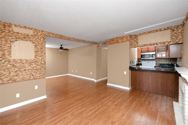 738 Haven Pl, Tarpon Springs, FL 34689 - kitchen featuring stainless steel microwave, white electric stove, brown cabinetry, a ceiling fan, and light wood-type flooring