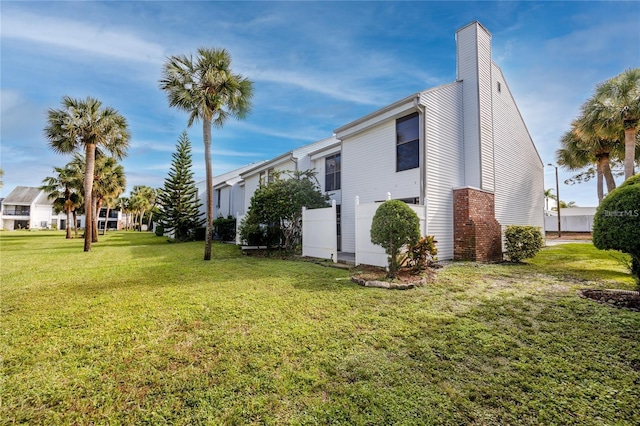 738 Haven Pl, Tarpon Springs, FL 34689 - view of side of home featuring a yard and a chimney