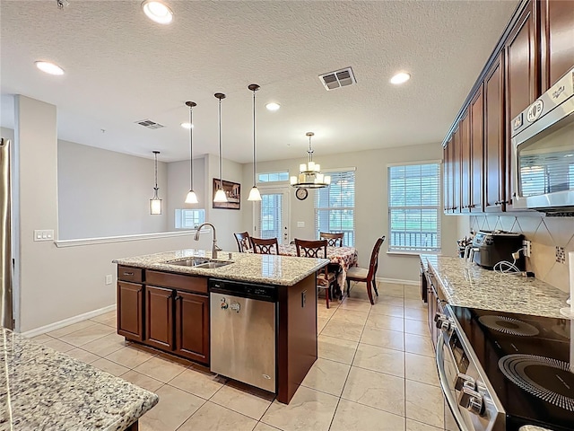 1027 Cedar Bay Ln, Winter Springs, FL 32708 - kitchen with stainless steel appliances, a sink, light stone countertops, recessed lighting, and dark brown cabinets