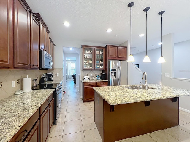 1027 Cedar Bay Ln, Winter Springs, FL 32708 - kitchen featuring appliances with stainless steel finishes, a sink, a breakfast bar area, decorative backsplash, and glass insert cabinets