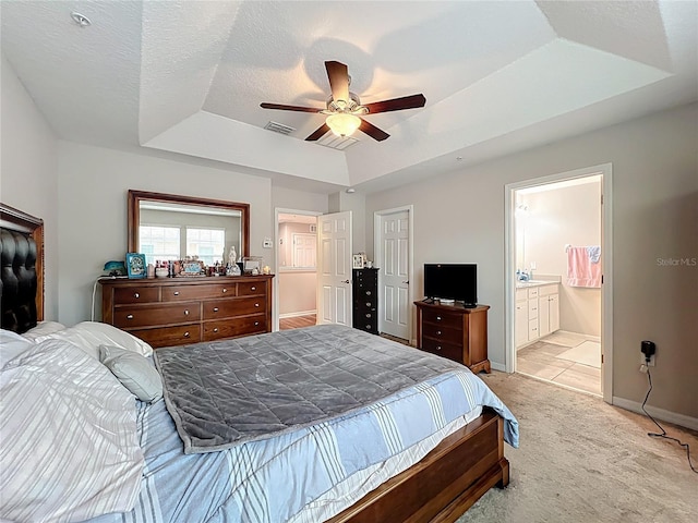 1027 Cedar Bay Ln, Winter Springs, FL 32708 - bedroom featuring a tray ceiling, light colored carpet, baseboards, ensuite bathroom, and a ceiling fan