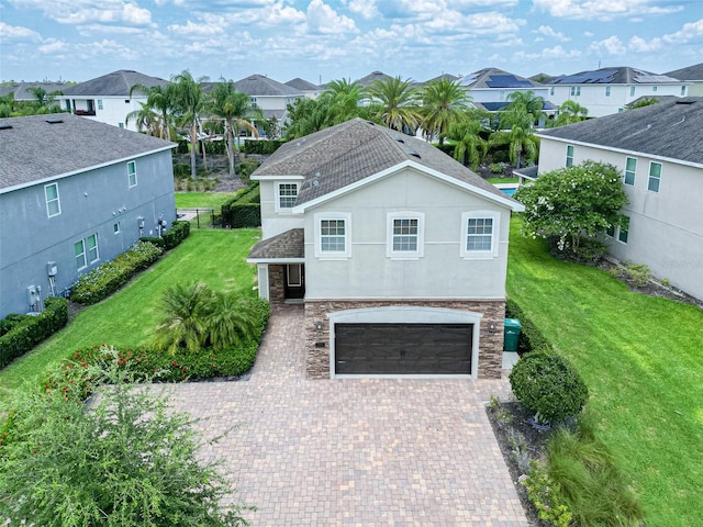 311 W Falls Dr, Kissimmee, FL 34747 - view of front of house with a residential view, an attached garage, stucco siding, stone siding, and decorative driveway
