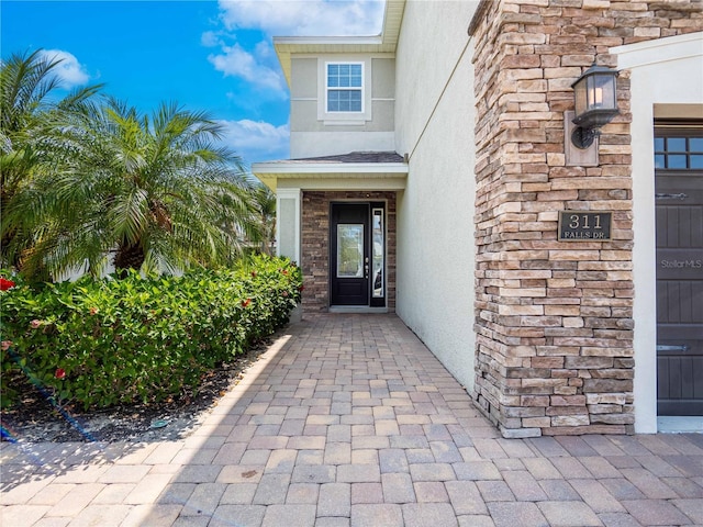 311 W Falls Dr, Kissimmee, FL 34747 - entrance to property featuring stucco siding and stone siding