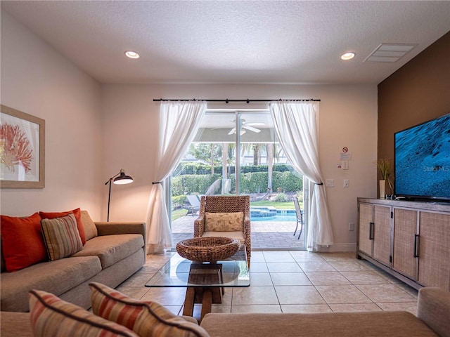 311 W Falls Dr, Kissimmee, FL 34747 - living room featuring a textured ceiling, light tile patterned flooring, recessed lighting, and baseboards
