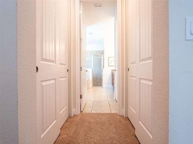 311 W Falls Dr, Kissimmee, FL 34747 - corridor with light carpet, a textured wall, and light tile patterned floors