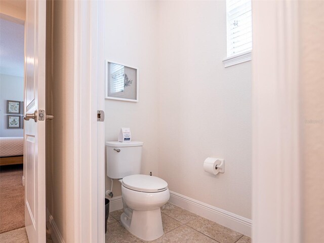 311 W Falls Dr, Kissimmee, FL 34747 - bathroom with toilet, baseboards, tile patterned flooring, and ensuite bathroom