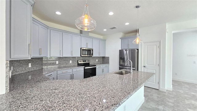 726 Coral Reef Way, Daytona Beach, FL 32124 - kitchen with appliances with stainless steel finishes, light stone counters, decorative backsplash, a sink, and a peninsula
