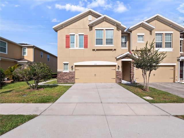 view of front of home with stucco siding, concrete driveway, an attached garage, stone siding, and a front lawn