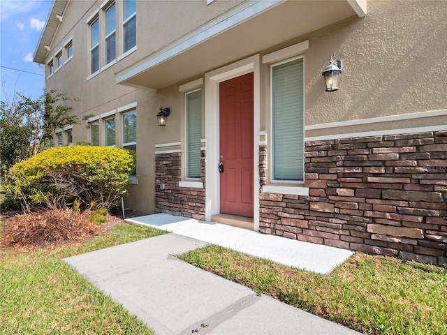 entrance to property with stucco siding and stone siding