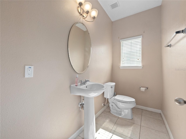 half bath with toilet, tile patterned floors, and baseboards
