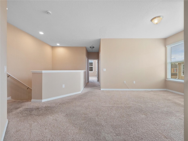 carpeted spare room featuring baseboards, a smoke detector, and recessed lighting