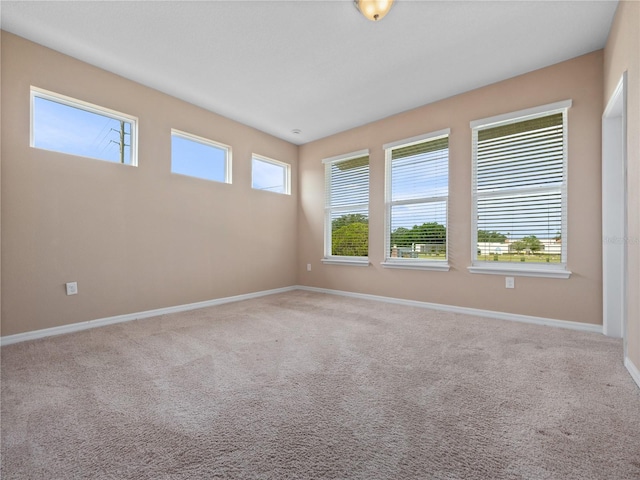 spare room with baseboards and carpet
