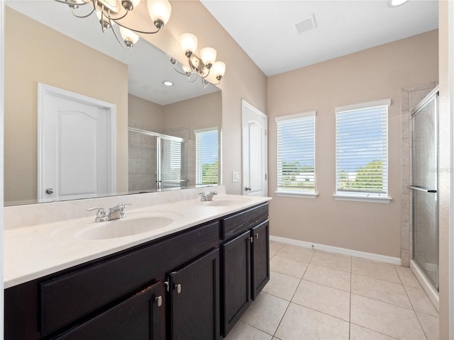 full bath featuring a shower stall, double vanity, a chandelier, tile patterned flooring, and baseboards