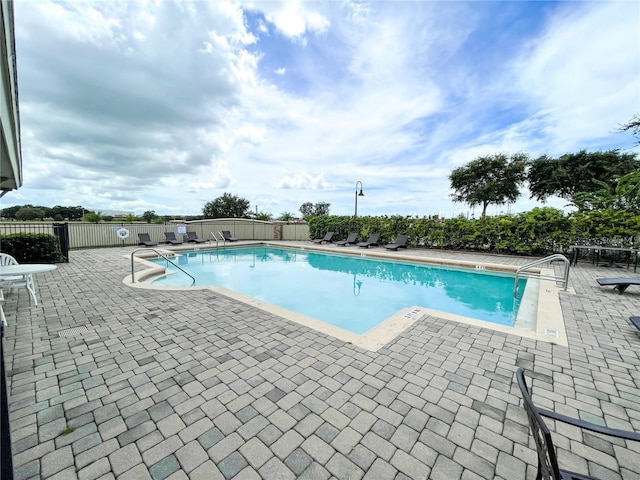 community pool featuring a patio and fence