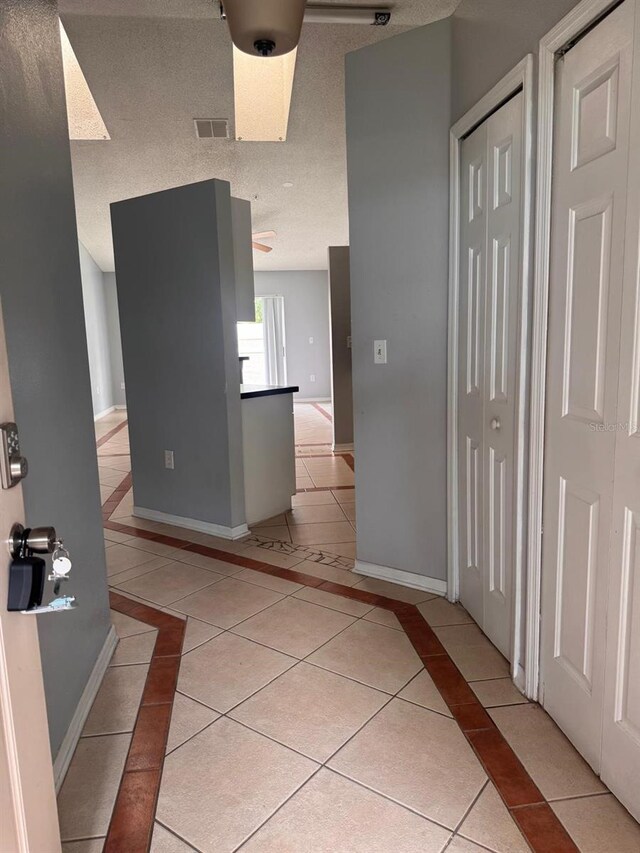 1603 Emily Ct, Kissimmee, FL 34744 - corridor with inlaid floor details, light tile patterned floors, and a textured ceiling