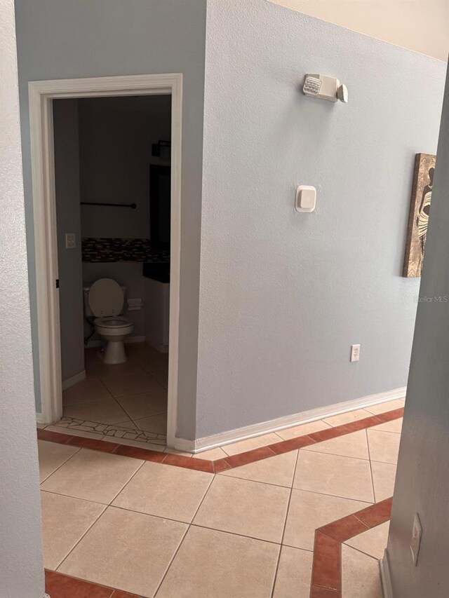 1603 Emily Ct, Kissimmee, FL 34744 - corridor featuring light tile patterned flooring and baseboards