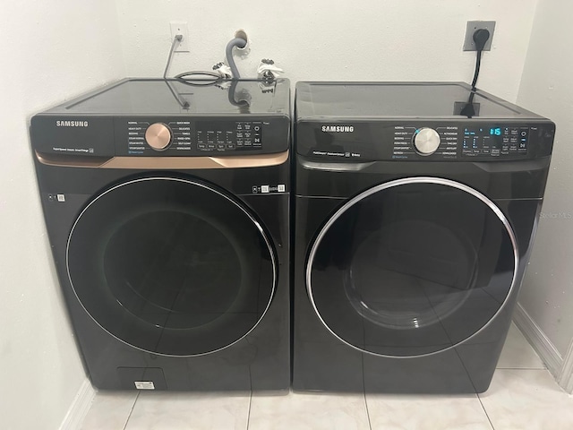 115 Bristol Forest Trl, Sanford, FL 32771 - clothes washing area with washing machine and dryer, tile patterned floors, and baseboards