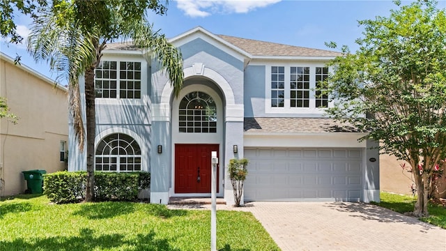 12917 Grovehurst Ave, Winter Garden, FL 34787 - view of front of home with decorative driveway, stucco siding, an attached garage, a front yard, and roof with shingles