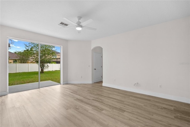 12917 Grovehurst Ave, Winter Garden, FL 34787 - spare room featuring arched walkways, light wood-type flooring, a ceiling fan, and baseboards