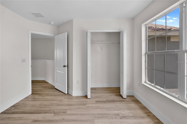 12917 Grovehurst Ave, Winter Garden, FL 34787 - unfurnished bedroom featuring light wood-type flooring, a closet, and baseboards