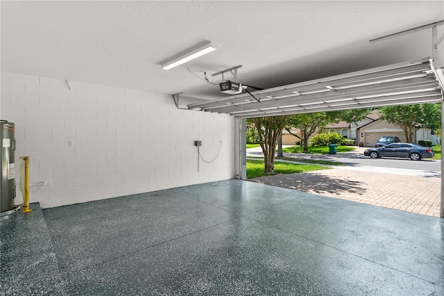 12917 Grovehurst Ave, Winter Garden, FL 34787 - garage featuring a garage door opener, electric water heater, and concrete block wall