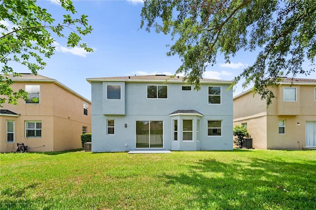 12917 Grovehurst Ave, Winter Garden, FL 34787 - back of property with stucco siding, a yard, and central AC unit