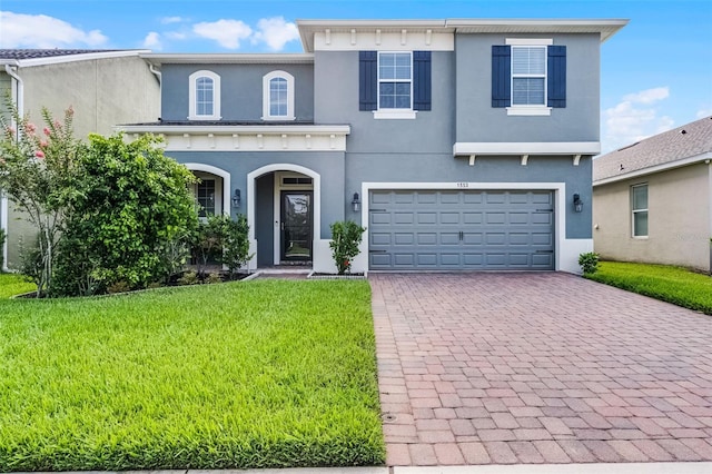 1553 Caterpillar St, Saint Cloud, FL 34771 - view of front facade with stucco siding, decorative driveway, a front yard, and a garage