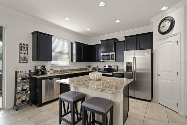 1553 Caterpillar St, Saint Cloud, FL 34771 - kitchen featuring appliances with stainless steel finishes, a sink, a center island, light stone counters, and dark cabinets