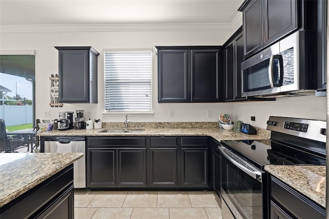 1553 Caterpillar St, Saint Cloud, FL 34771 - kitchen with appliances with stainless steel finishes, a sink, crown molding, dark cabinetry, and light stone countertops