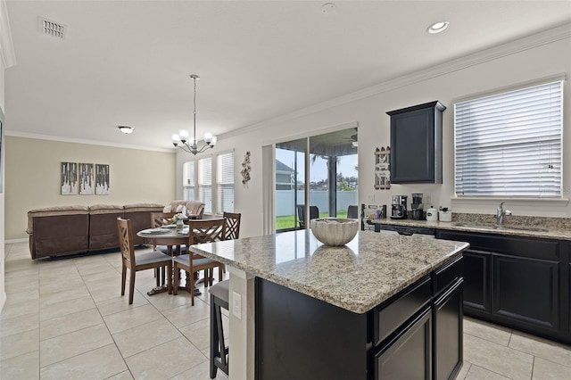 1553 Caterpillar St, Saint Cloud, FL 34771 - kitchen featuring a sink, light tile patterned floors, crown molding, open floor plan, and a center island