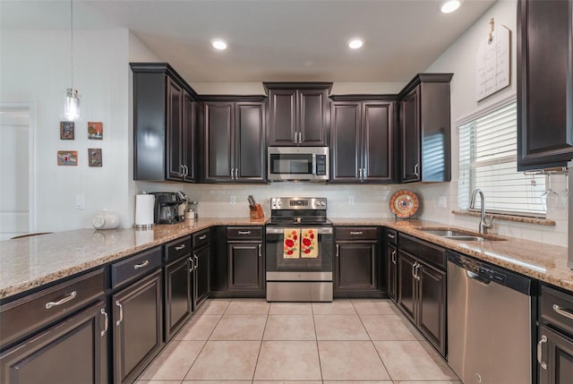 11631 Mystery Ln, Orlando, FL 32832 - kitchen featuring stainless steel appliances, a sink, light stone counters, decorative backsplash, and light tile patterned floors