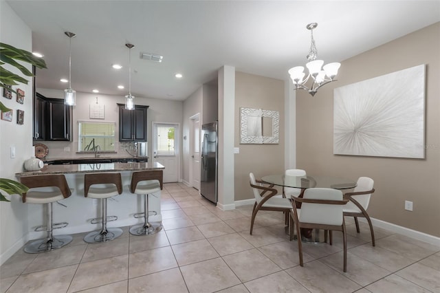 11631 Mystery Ln, Orlando, FL 32832 - kitchen featuring freestanding refrigerator, light stone countertops, a breakfast bar, a peninsula, and a chandelier