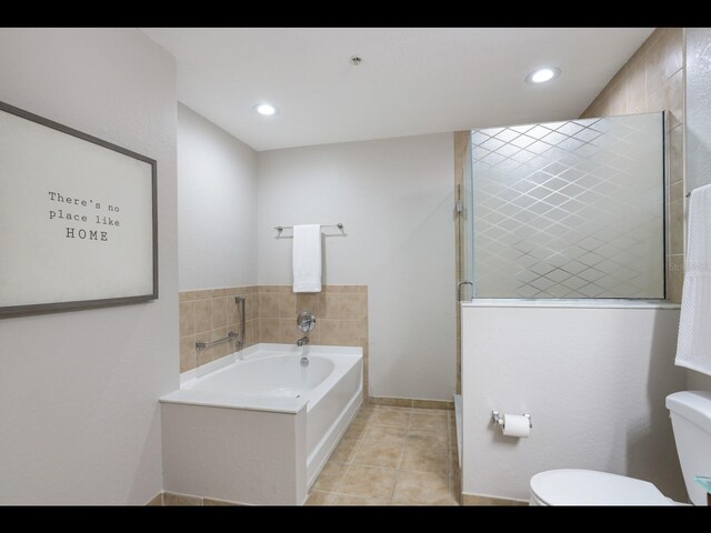 1064 N Tamiami Trl Unit 1219, Sarasota, FL 34236 - bathroom with toilet, tile patterned flooring, a garden tub, a shower stall, and recessed lighting