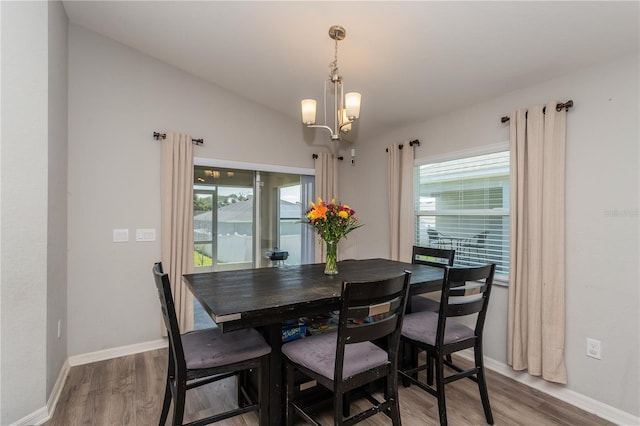 871 Orleans Dr, Eagle Lake, FL 33839 - dining space with wood finished floors, baseboards, plenty of natural light, and a chandelier