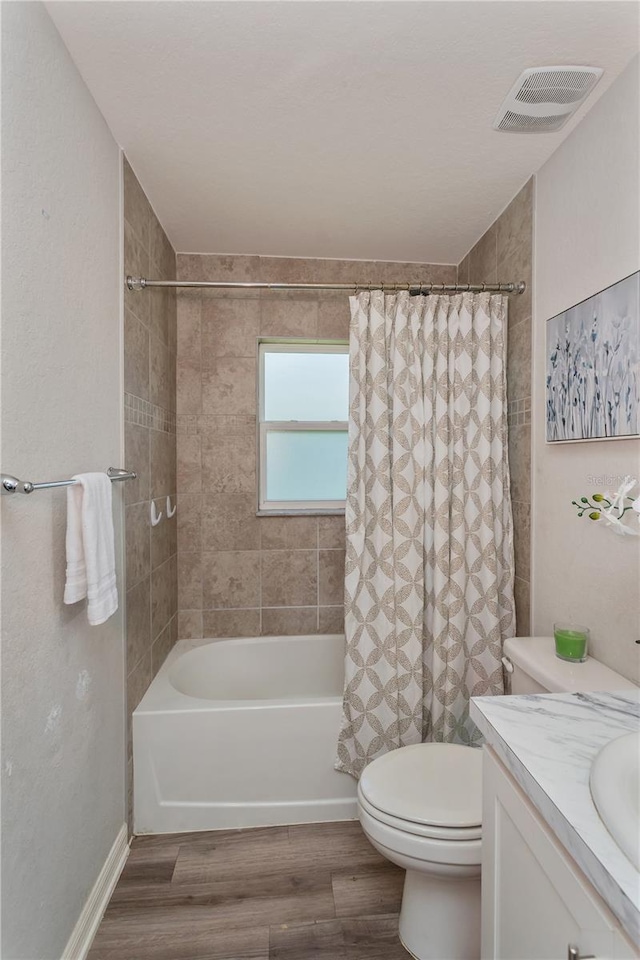 871 Orleans Dr, Eagle Lake, FL 33839 - bathroom featuring wood finished floors, toilet, shower / bathtub combination with curtain, and vanity