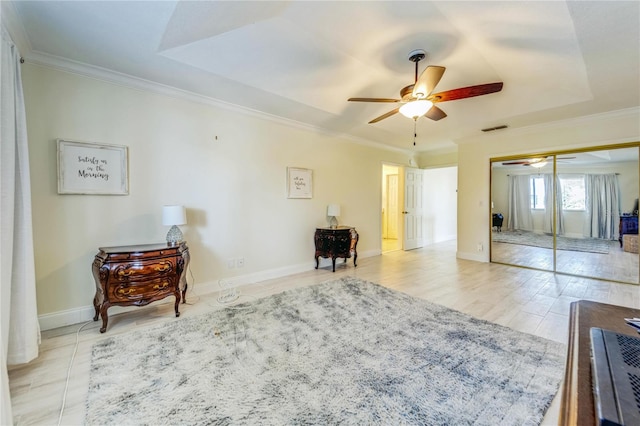 1672 Watermark Cir NE, Saint Petersburg, FL 33702 - bedroom with crown molding, baseboards, a closet, a ceiling fan, and a tray ceiling