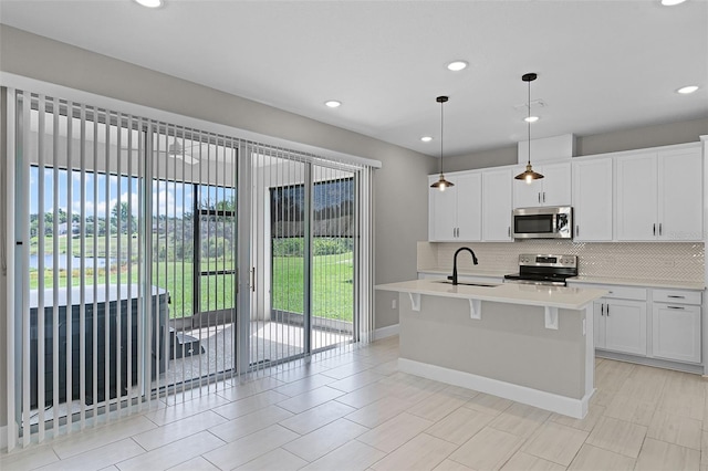 10249 Spring Lake Dr, Clermont, FL 34711 - kitchen featuring stainless steel appliances, tasteful backsplash, light countertops, a center island with sink, and recessed lighting