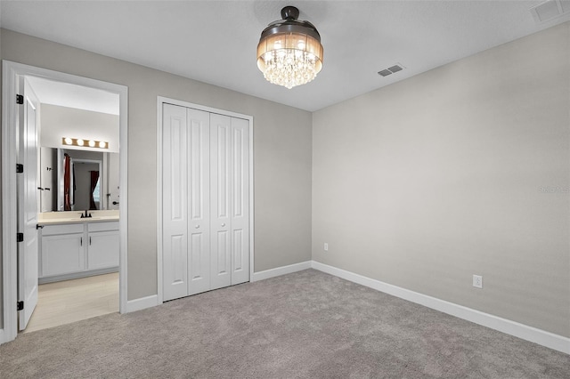 10249 Spring Lake Dr, Clermont, FL 34711 - unfurnished bedroom with light carpet, a chandelier, a closet, and ensuite bath
