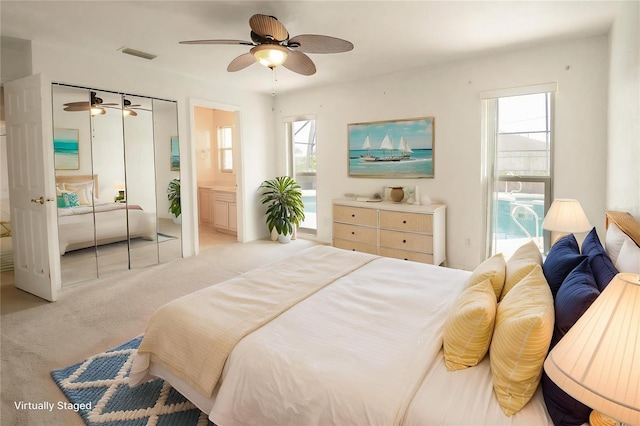 2 Pirates Cv, Ormond Beach, FL 32176 - carpeted bedroom featuring multiple windows, a ceiling fan, and connected bathroom
