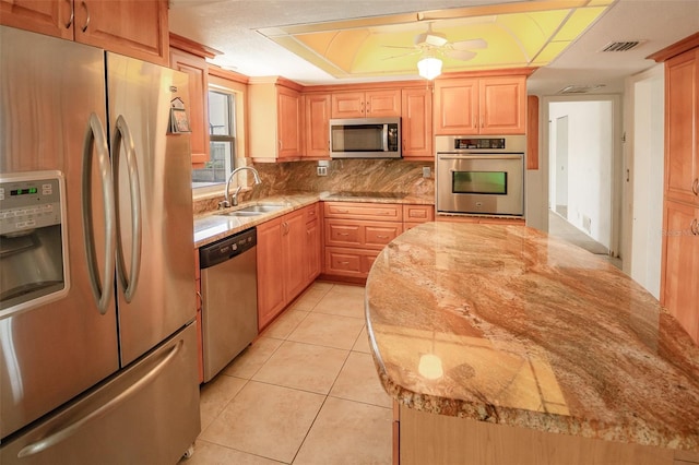 2 Pirates Cv, Ormond Beach, FL 32176 - kitchen with stainless steel appliances, a sink, backsplash, light tile patterned flooring, and light stone counters