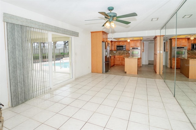 2 Pirates Cv, Ormond Beach, FL 32176 - kitchen with stainless steel appliances, decorative backsplash, a ceiling fan, a kitchen island, and brown cabinets