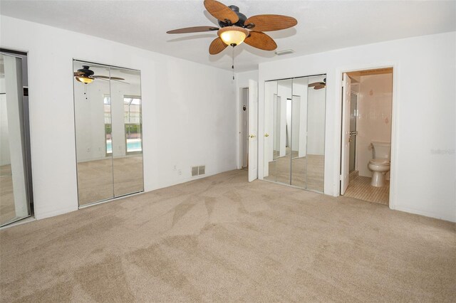 2 Pirates Cv, Ormond Beach, FL 32176 - unfurnished bedroom featuring carpet floors, multiple closets, connected bathroom, and a ceiling fan